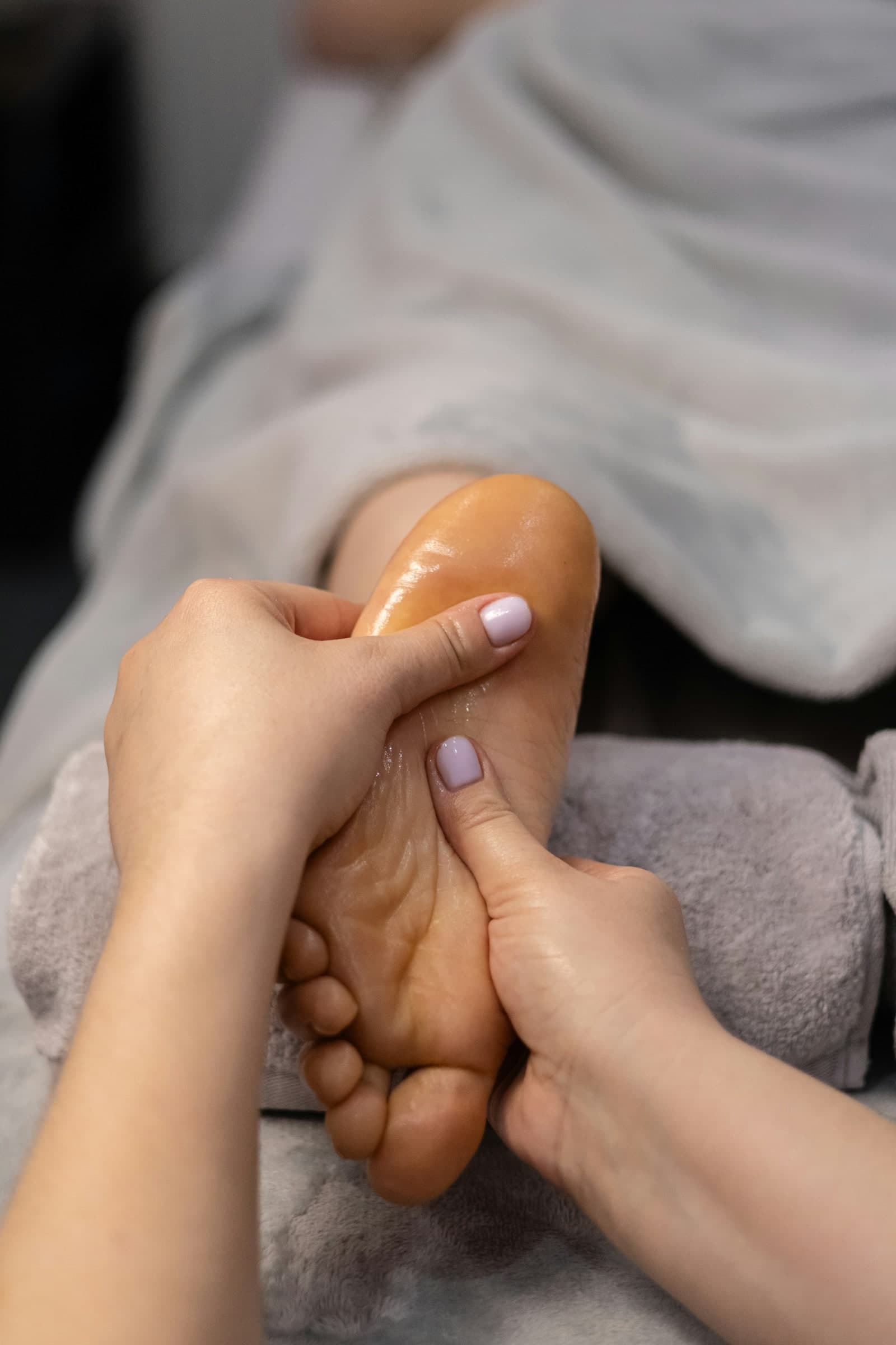Registered massage therapist massaging a client's foot during a treatment at Cypri Massage Therapy in Toronto, ON